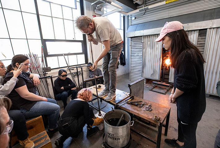 Teacher demonstrating glassblowing techniques. Links to Gifts of Appreciated Securities